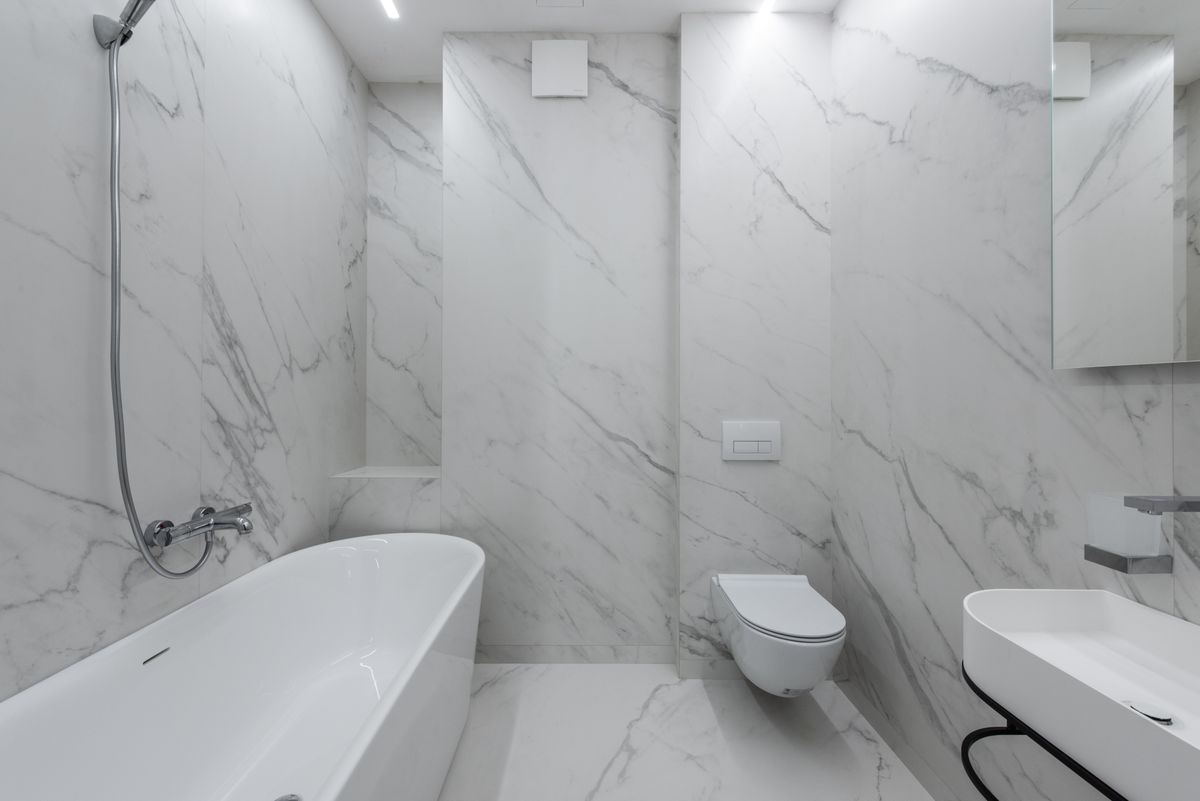 New toilet installed in a modern Dallas, TX bathroom with marble tile