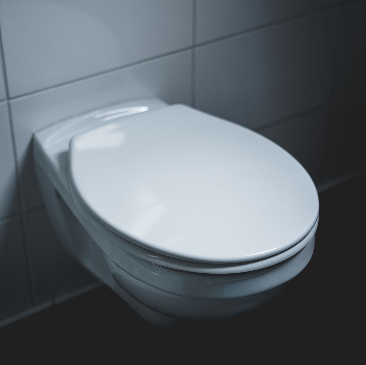 Closed toilet seat in a Dallas, TX bathroom with a clog problem
